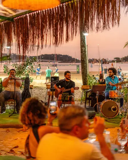 Banda tocando ao vivo no palco externo do Clericot, ao pôr do sol