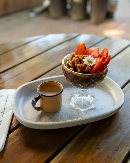 Taça com morangos e crocante acompanhada de um café